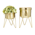 Front view of two gold metal planters with removable hairpin stands, one shorter with faux green flowers