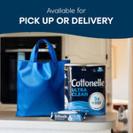 Cottonelle Ultra Clean toilet paper roll and a blue reusable shopping bag on a counter with a Cottonelle wipes pack in front.