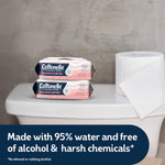 Two Cottonelle Fragrance-Free flushable wipes packs on a toilet tank next to a roll of toilet paper