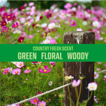 Green banner over a flower-filled meadow reading “Country Fresh Scent” with descriptors: green, floral, woody.