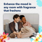 Lifestyle image of a smiling couple seated on a couch with headline 'Enhance the mood in any room with fragrance that freshens' and floral graphics.