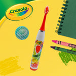 Crayola-branded sonic toothbrush angled on a yellow background with crayons and a holographic travel cap graphic