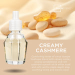 Close-up promotional graphic of a clear fragrance oil bottle over a soft beige background with stones and Mainstays logo and 'Creamy Cashmere' text.