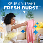 Lifestyle image of a person holding up freshly laundered clothing with overlaid text "Crisp & Vibrant Fresh Burst scent" and sparkle graphics