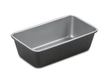 Gray nonstick metal loaf pan with rounded corners and tapered sides on white