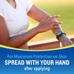 Close-up of a person rubbing repellent on their forearm with instruction to spread with your hand after applying