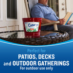 Cutter red outdoor candle on a patio table with a seated person blurred in the background