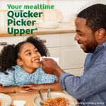 Father wiping a child's face with a Bounty napkin at a kitchen table, product slogan visible