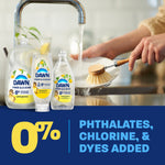 Lifestyle image of hands washing a dish at a sink with three Dawn Free & Clear lemon bottles and '0%' claim