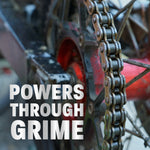 Close-up of a greasy bicycle chain and sprocket with overlay text 'Powers Through Grime' promoting cleaning power.