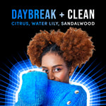 Lifestyle graphic with model peeking over a blue sweater and text describing Daybreak + Clean fragrance notes
