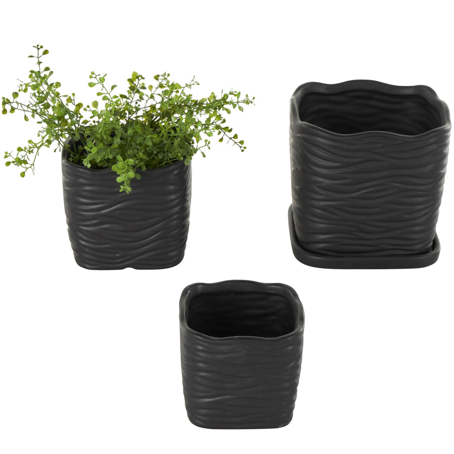 Three black wavy-ribbed ceramic planters shown separately; one planted with greenery