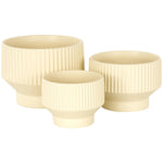 Three cream ribbed ceramic planters grouped together on white background, showing different sizes and shapes.