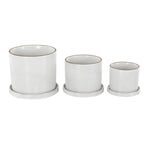 Three white DecMode ceramic planters with fine grid pattern and brown-rimmed openings, arranged left-to-right small to large on saucers