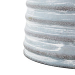 Close-up of ribbed lower body showing painted weathered finish on a gray metal watering can