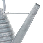 Detail view of the long angled spout and top attachment of a weathered gray metal watering can