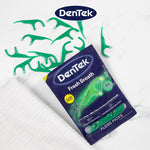 Flat lay scene with DenTek pouch and loose green floss picks arranged on a white surface with logo
