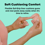 Hands holding a denture with a finger peeling away soft cushioning liner, product text above