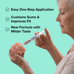 Person applying Dentemp Sof-Grip from a syringe to a denture with feature text on turquoise background