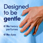 Close-up of a hand on soft blue fabric with text 'Designed to be gentle' and callouts for no heavy perfumes and no dyes