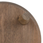 Tight detail of a single wooden plant stand leg attached to the underside of a round wooden top