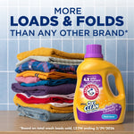 Folded laundry stack beside a yellow Arm & Hammer plus OxiClean detergent bottle with promotional headline about loads and folds