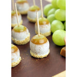 Small dessert or cheese bites pierced with wooden toothpicks displayed beside green grapes