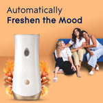 Glade automatic dispenser with three smiling people seated on a couch in the background and floral accents