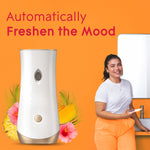 Glade automatic dispenser shown alongside a smiling person and tropical floral accents with text ‘Automatically Freshen the Mood’.