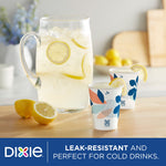 Two Dixie patterned paper cups on a table with a pitcher of lemonade and lemons
