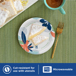 Dixie floral paper plate on a placemat with powdered pastry pieces and a cup of coffee nearby