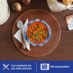 Dixie Ultra blue swirl paper bowl on a woven placemat filled with vegetable soup, accompanied by spoon and napkin.