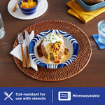 Table setting with a Dixie Ultra blue-patterned paper plate holding a loaded baked potato, utensils and placemat visible