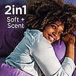 Smiling person lying on a purple pillow with copy reading '2in1 Soft + Scent' promoting Downy Calm fabric softener benefits.