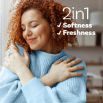 Smiling woman hugging a blue sweater with overlay text '2in1 Softness ✓ Freshness' in the corner