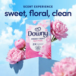 Downy April Fresh box displayed with pink peonies on a pedestal against a blue sky and 'sweet, floral, clean' text