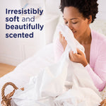 Person smelling freshly laundered white linens with copy reading “Irresistibly soft and beautifully scented” for Downy April Fresh