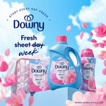 Grouped Downy April Fresh products including box, liquid bottle and scent beads with petals and sky backdrop