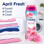 Downy April Fresh bottle beside folded laundry and pink flowers with descriptive scent text.