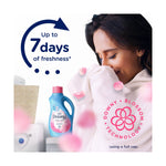 Woman smelling a white towel with a Downy April Fresh bottle in the background and 'Up to 7 days of freshness' text.