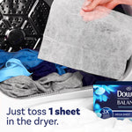 Hand holding a dryer sheet above laundry inside a dryer drum, with a small Downy BALANCE box visible and 'Just toss 1 sheet' text.