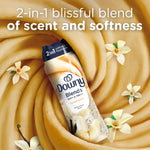 Downy Blends Toasted Vanilla bottle surrounded by vanilla flowers and a swirled cream background emphasizing scent and softness
