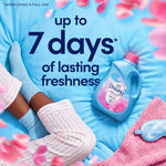 Downy bottle on a bed with socks and sleep accessories, text claims up to 7 days of lasting freshness.