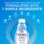 Downy Rinse Out Odor bottle centered in water ring with icons and ‘7 simple ingredients’ text