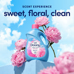 Downy laundry bottle displayed on a pedestal surrounded by pink peony flowers against blue sky