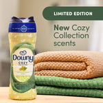 Downy Cozy Collection pistachio cream scent bottle staged next to folded green and tan towels with limited edition banner