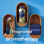 Downy Calm bottle displayed in a wooden shelf vignette with folded towels and reed diffuser on blue wall