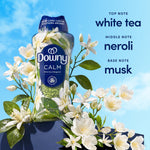 Downy Calm scent booster bottle surrounded by white blossoms with text listing fragrance notes on a blue background