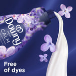 Downy Calm bottle pouring white liquid with purple flower petals and a callout stating the product is free of dyes