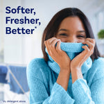 Smiling person breathing into a blue sweater with 'Softer, Fresher, Better' headline promoting Downy